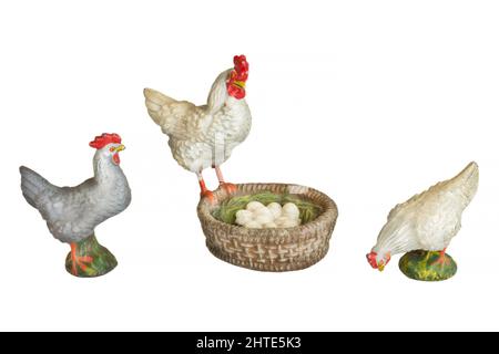 Trois poulets de jouet vintage avec panier rempli d'oeufs isolés sur un fond blanc Banque D'Images