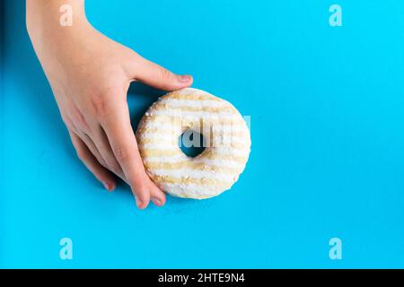Main tenant moitié mangé doux rose beignet isolé.Demi mangé donut isolé. Banque D'Images
