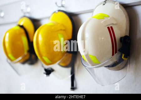 Protection contre les risques professionnels. Prise de casques de pompier suspendus à un mur. Banque D'Images