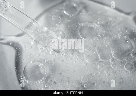 Gel cosmétique transparent à l'aloe vera dans une boîte de Petri avec une pipette. Photo macro d'une structure de gel avec des bulles. Banque D'Images