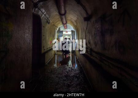 Homme explorant le vieux bunker de la Seconde Guerre mondiale avec une lampe de poche Banque D'Images