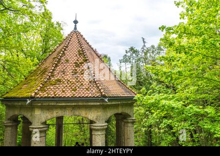 Gros plan d'un pavillon en pierre de mousse avec de grands arbres autour Banque D'Images
