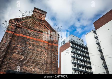 Contrastant avec des immeubles modernes de grande hauteur contre un bâtiment victorien en brique abandonné sur Brick Street, au centre-ville de Liverpool. Banque D'Images