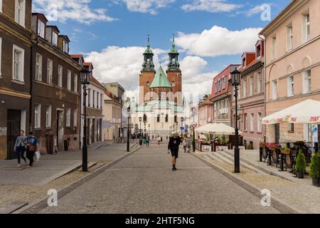 Rue menant à une cathédrale en brique gothique dans la ville historique de Gniezno Banque D'Images