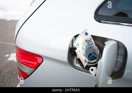 Réservoir de carburant de voiture rempli d'argent. Concept d'augmentation du prix du gaz Banque D'Images