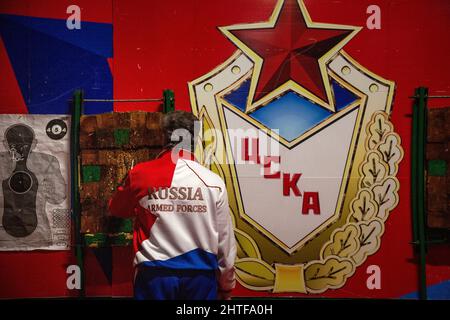 Région de Moscou, Russie. 26th de février 2022 Un homme lance des couteaux sur des cibles contre le fond de l'emblème du club sportif CSKA dans un musée sur le territoire du Parc patriote militaire-patriotique dans la région de Moscou, dédié au défenseur de la Journée de la Patrie. L'inscription est « CSKA » Banque D'Images