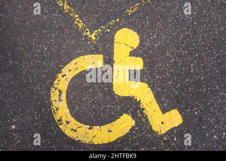 Gros plan du Badge Bleu symbole du fauteuil roulant et les personnes handicapées la signalisation de stationnement dans un parking bay Banque D'Images