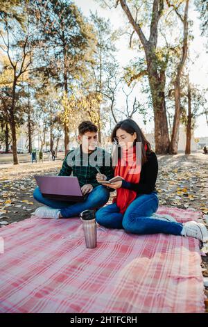 jeune couple utilisant un ordinateur portable pour travailler à l'extérieur Banque D'Images