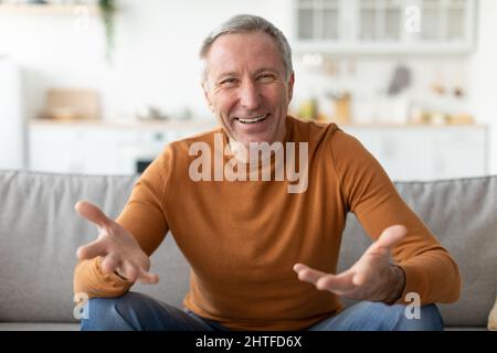 Homme mûr parlant et faisant des gestes à l'appareil photo Banque D'Images