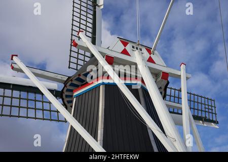 Moulin à vent hollandais typique en hiver avec eau gelée et ciel bleu avec quelques nuages Banque D'Images