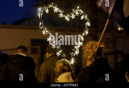 Rostock, Allemagne. 28th févr. 2022. Lors d'une manifestation contre les mesures de Corona et la vaccination obligatoire, une femme porte un coeur fait d'étoiles brillantes. Credit: Bernd Wüstneck/dpa-Zentralbild/dpa/Alay Live News Banque D'Images