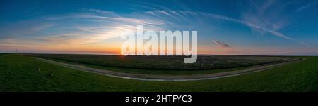 Coucher de soleil panoramique avec de doux nuages colorés sur une pelouse vivivivivivivibrer Banque D'Images