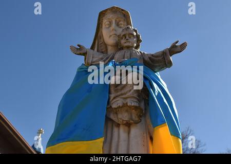 Pittston, États-Unis. 28th févr. 2022. Le drapeau de l'Ukraine a été attaché autour d'une statue de la Vierge Marie et de Jésus-Christ à l'extérieur de l'église Saint-Michel. Crédit : SOPA Images Limited/Alamy Live News Banque D'Images