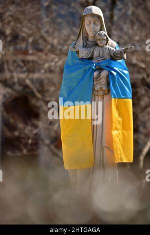 Pittston, États-Unis. 28th févr. 2022. Le drapeau de l'Ukraine a été attaché autour d'une statue de la Vierge Marie et de Jésus-Christ à l'extérieur de l'église Saint-Michel. Crédit : SOPA Images Limited/Alamy Live News Banque D'Images