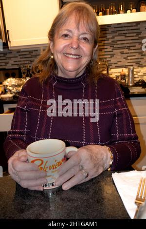 Belle photographe Mary Skjold tenant une tasse de café souriant dans la cuisine. St Paul Minnesota MN États-Unis Banque D'Images