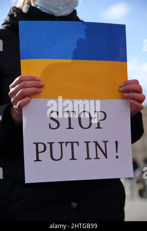 Banenr avec la couleur nationale du drapeau ukrainien et du texte ARRÊTER POUTINE tenir par le manifestant pendant la manifestation contre l'agression russe en Ukraine Banque D'Images