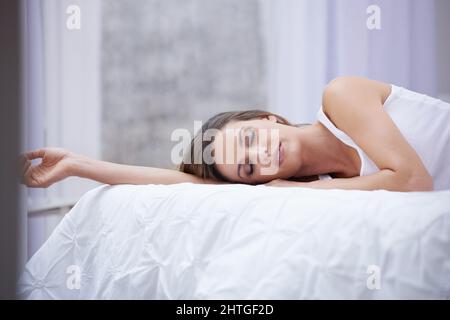 Dormez bien Photo d'une belle jeune femme dormant dans son lit. Banque D'Images