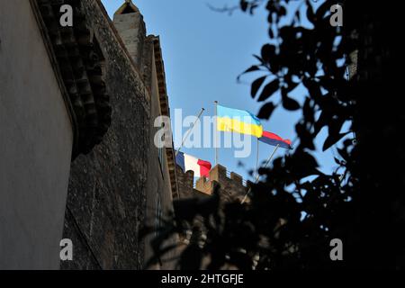 Cagnes sur Mer, France - 28 février 2022 : drapeau ukrainien flotté en solidarité au sommet du Château Grimaldi, montré entre la végétation au niveau du sol. Banque D'Images