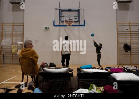 Przemysl, Varsovie, Pologne. 28th févr. 2022. Les enfants jouent au basket-ball dans un abri temporaire situé dans une salle de gym de l'école primaire le 28 février 2022 à Przemysl, en Pologne. Selon le ministère de l'intérieur, plus de 320,000 personnes fuyant l'Ukraine déchirée par la guerre ont traversé la frontière avec la Pologne en février 28, et plus de 40,000 ont trouvé refuge et premiers secours dans les points de désorption. (Image de crédit : © Aleksander Kalka/ZUMA Press Wire) Banque D'Images