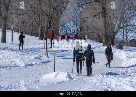 Montréal, CA - 26 février 2022 : personnes marchant ou skiant sur un sentier enneigé dans le parc du Mont-Royal de Montréal (Parc du Mont-Royal) après une tempête de neige. Banque D'Images