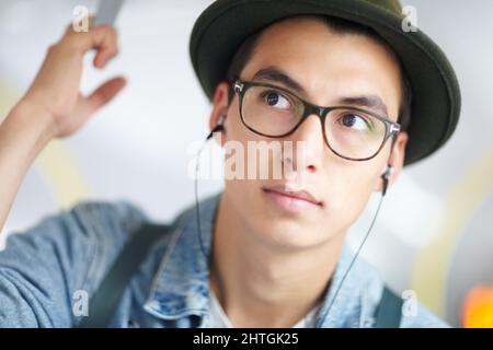 Musique nomade. Jeune homme prenant les transports en commun tout en écoutant son joueur de mp3. Musique nomade. Jeune homme prenant les transports en commun tout en écoutant son joueur de mp3.