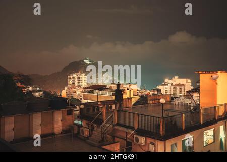 Une nuit, longue exposition photo d'une zone résidentielle de favela à Babilonia, dans le district de Leme de Rio de Janeiro, Brésil, avec de multiples toits éclairés de Banque D'Images