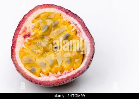 Moitié de fruit de la passion, maracuja, sur fond blanc. La phographie alimentaire. Banque D'Images