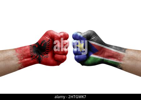 Deux mains poinçonner l'une à l'autre sur fond blanc. Drapeaux de pays peints poings, concept de crise de conflit entre l'albanie et le Sud soudan Banque D'Images