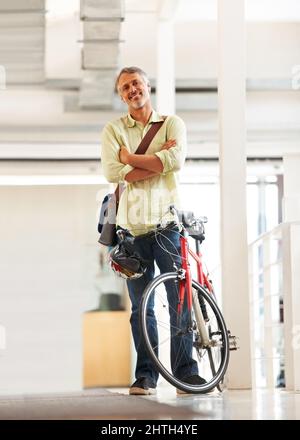 Faire les livraisons de jours. Prise de vue en longueur d'un beau messager de vélo dans un bureau. Banque D'Images