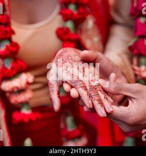 Cet anneau est un signe de mon amour. Photo rognée d'un couple hindou échangeant des anneaux le jour de leur mariage. Banque D'Images