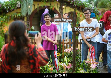 Les amis sont enthousiastes et prennent des photos avec la réplique de la maison hobbiton lors de l'événement FLORIA à Putrajaya, Malaisie . Un présentoir de la maison hobbit présenté dans Lord O Banque D'Images