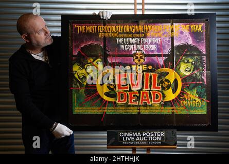 Mark Hochman, consultant en posters chez prop Store, regarde un quad au Royaume-Uni (version 1st) pour le film de 1981 « The Evil Dead » (est. £200 - £300) pendant un aperçu à leur maison de vente aux enchères à Rickmansworth, Hertfordshire. Date de la photo: Mercredi 16 février 2022. Banque D'Images