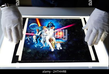 Mark Hochman, consultant en posters du prop Store, place une transparence de l'œuvre d'art de l'affiche C de style quad du Royaume-Uni, issue du 1977 film Star Wars: A New Hope (est. £1 500 - £2 500) sur une visionneuse lors d'un aperçu à leur maison de vente aux enchères à Rickmansworth, Hertfordshire. Date de la photo: Mercredi 16 février 2022. Banque D'Images