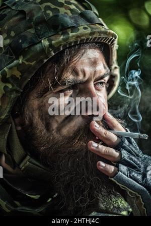 Portrait en gros plan des soldats russes ou ukrainiens qui fument. La Russie contre l'Ukraine soldat. Soldat fatigué. Banque D'Images