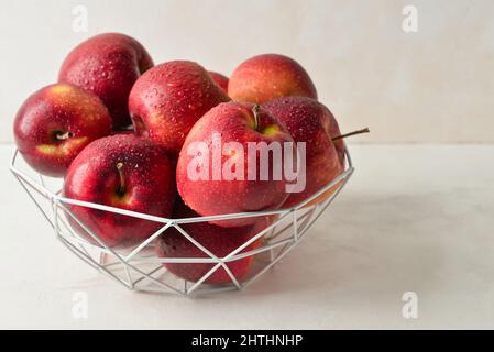 Panier avec pommes fraîches sur fond clair Banque D'Images