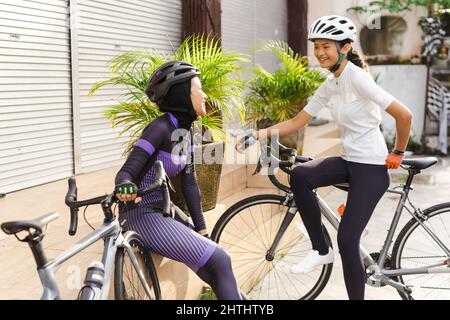 le cycliste musulman fait une pause et a une conversation sur le côté de la route Banque D'Images