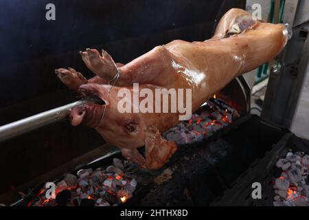 Le porc est grillé lentement sur la broche de manière traditionnelle Banque D'Images