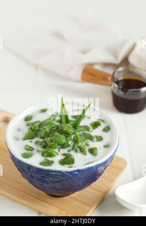 Es Cendol ou Dawet est un dessert traditionnel indonésien glacé à base de farine de riz, de sucre de palme, de lait de noix de coco et de feuilles de Pandan servi dans un bol bleu. Populaire Banque D'Images