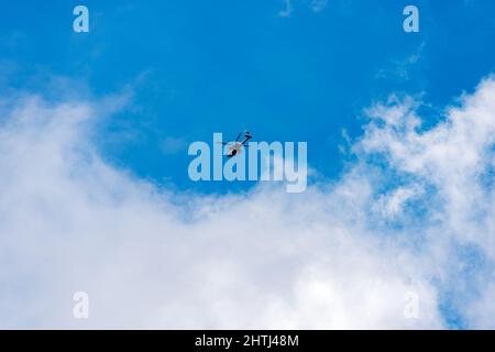 Hélicoptère militaire italien en mouvement contre un ciel bleu clair avec des nuages, Alpes italiennes, Trentin-Haut-Adige, Italie, Europe. Banque D'Images