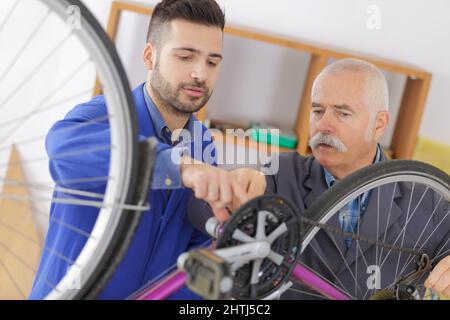 mécanicien de vélo et stagiaire travaillant à vélo Banque D'Images