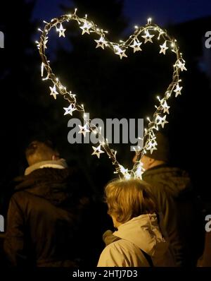 Rostock, Allemagne. 28th févr. 2022. Lors d'une manifestation contre les mesures de Corona et la vaccination obligatoire, une femme porte un coeur fait d'étoiles brillantes. Credit: Bernd Wüstneck/dpa-Zentralbild/dpa/Alay Live News Banque D'Images