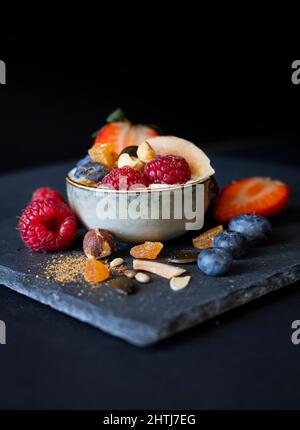 Muesli maison aux cocos, tournesol, Flex, citrouille et graines de sésame accompagnés de yaourt naturel et d'une variété fraîche de baies et de masala de garam Banque D'Images