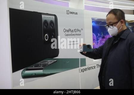 Barcelone, Espagne. 28th févr. 2022. Un visiteur regarde le smartphone OnePlus 10 Pro sur le stand de la société le jour de l'ouverture du Mobile World Congress (MWC), le salon annuel organisé par la GSMA à la Fira de Barcelona, Espagne. Banque D'Images