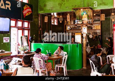 Mandalay, Myanmar - 04.17.2017: Clients asiatiques assis à des tables et parlant entre eux dans un restaurant local Banque D'Images