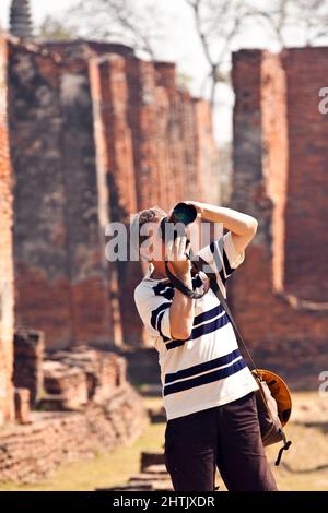 Man prend des photos dans le célèbre temple Wat Phra si Sanphet Banque D'Images