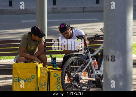BARCELONE, ESPAGNE - 4 OCTOBRE 2019 deux cyclistes de livraison assis sur un banc de parc en conversation Banque D'Images