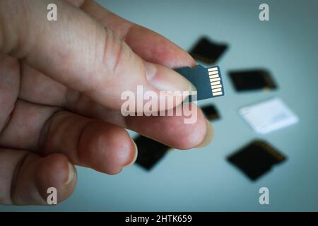 Carte mémoire microSD à portée de main sur un arrière-plan flou des autres cartes mémoire SD. Banque D'Images