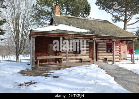 Cabane en rondins enneigée dans le parc public. Banque D'Images