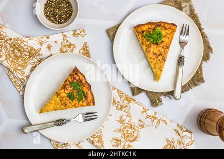Deux morceaux d'un gâteau de pommes de terre, tortilla espagnole, frittata, sur fond blanc, vue de dessus Banque D'Images