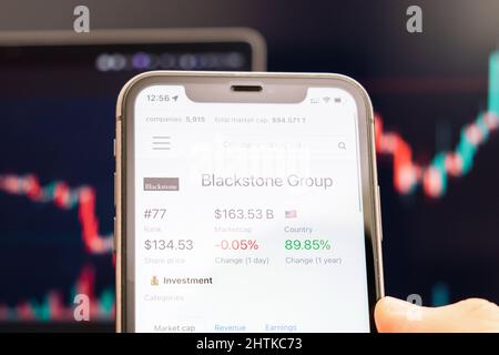 Blackstone Group cours de l'action sur l'écran de téléphone cellulaire dans les mains de l'évolution de la bourse avec échange de chandelier analyse graphique, février 2022, San Francisco, USA Banque D'Images